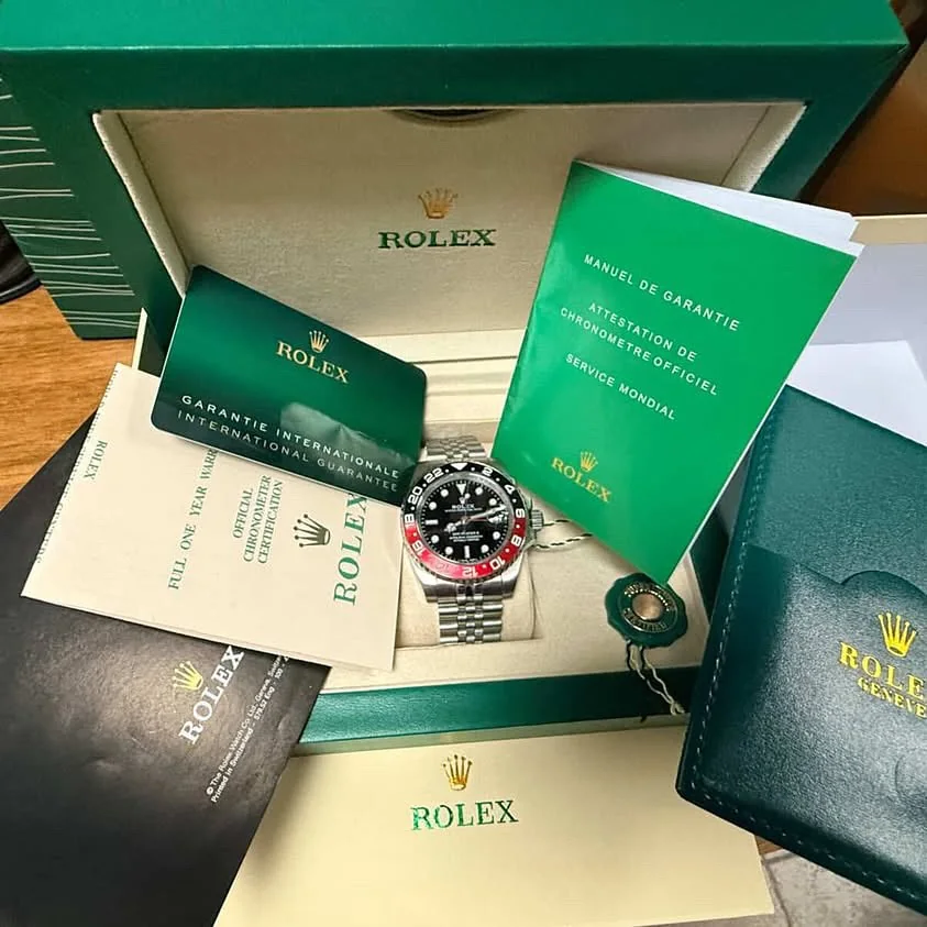 Rolex GMT Master II con bisel rojo y negro dentro de su caja verde, con manual y garantía